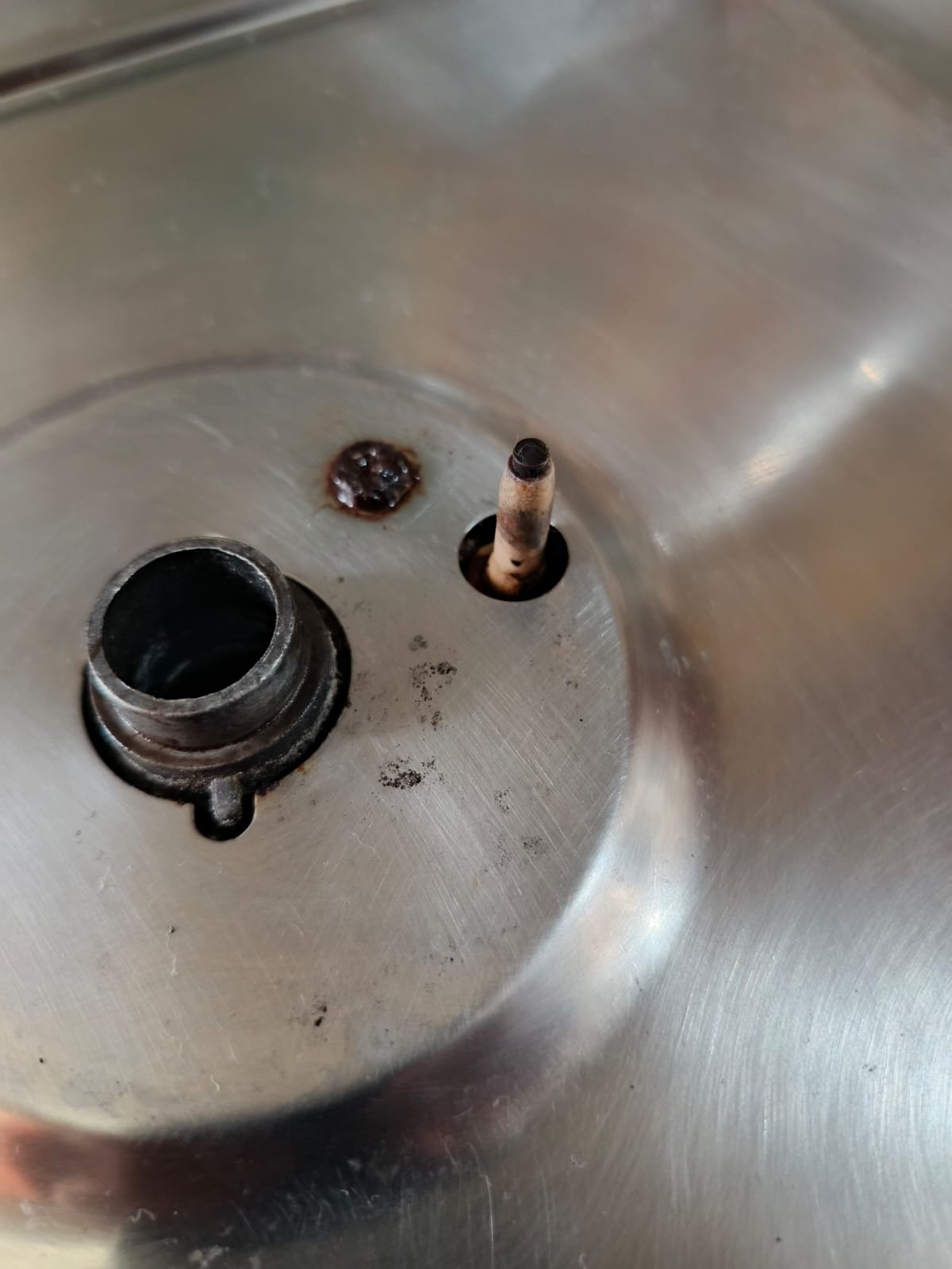 Detalhe da área de acendimento de um fogão registrado durante atendimento técnico.